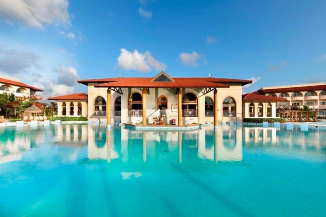 Vista da piscina principal com detalhes da fachada do resort